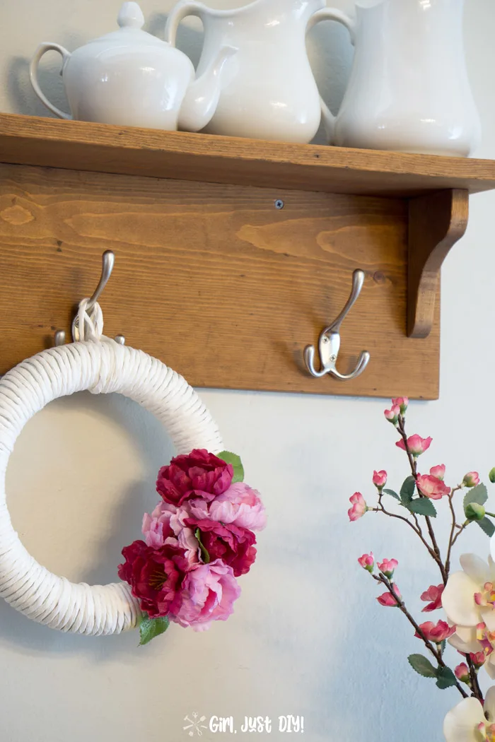 close-up of diy coat rack with a wreath hung in the center.