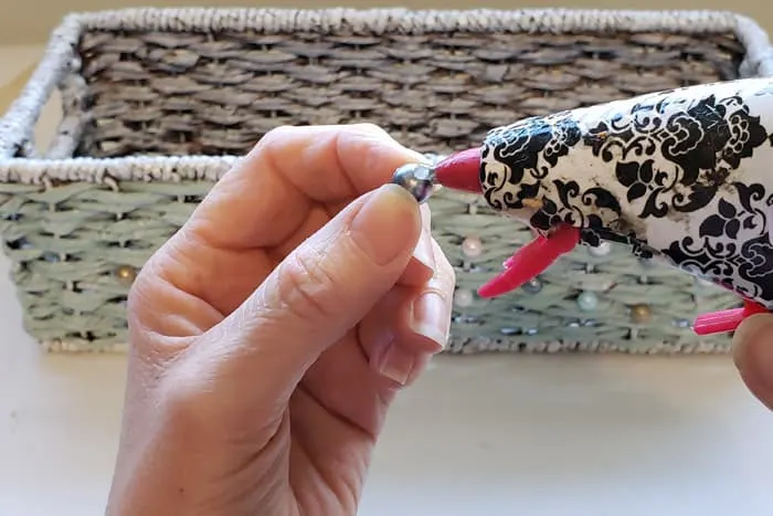 hot gluing beads to the front of the painted wicker basket