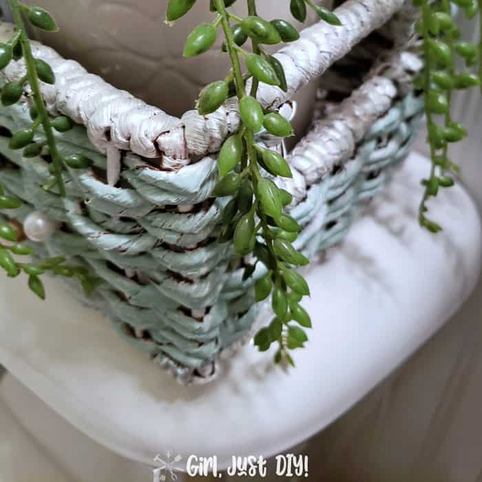 painted wicker basket with green houseplant on toilet tank
