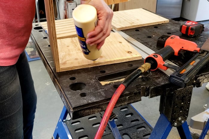 applying wood glue under side board for plywood storage rack