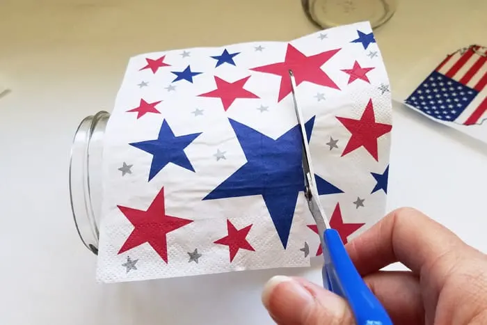 Cutting 4th of july napkin to size on jar