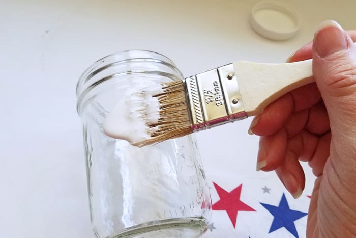 painting mod podge onto mason jar