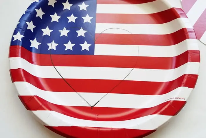 A heart traced onto an american flag paper plate.
