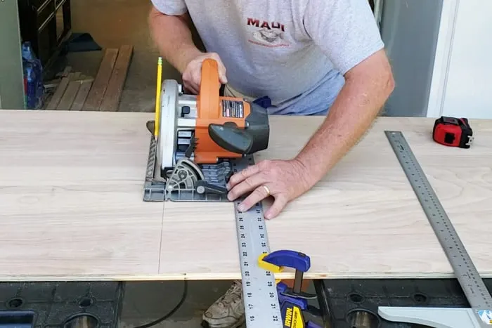 Cutting plywood with circular saw and straight edge clamped to board.