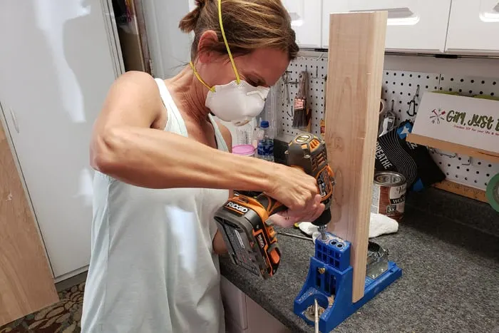 Woman drilling pocket holes into 2x4s with cordless drill