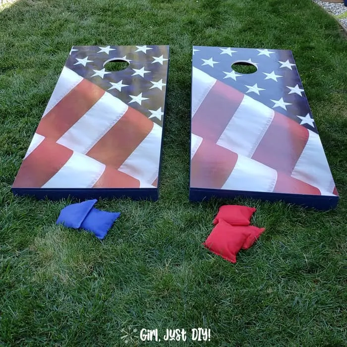 Set of cornhole boards on grass with beanbags.