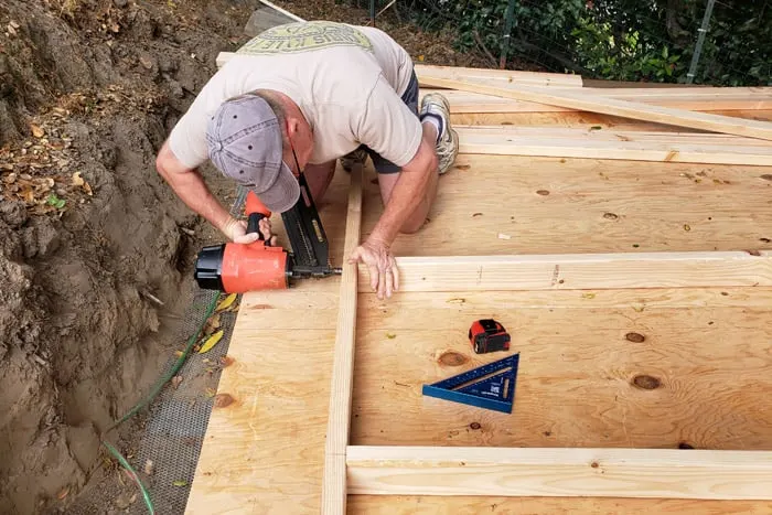 Man nailing into wall framing