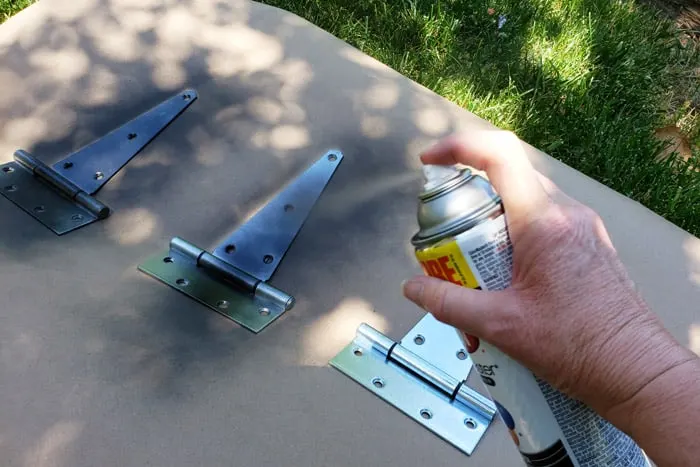 spray painting shed door hinges black.