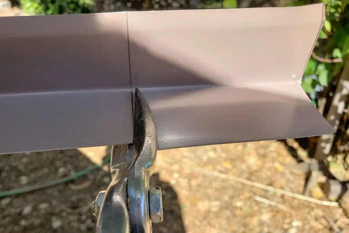 closeup of cutting aluminum drip edge with tin snips