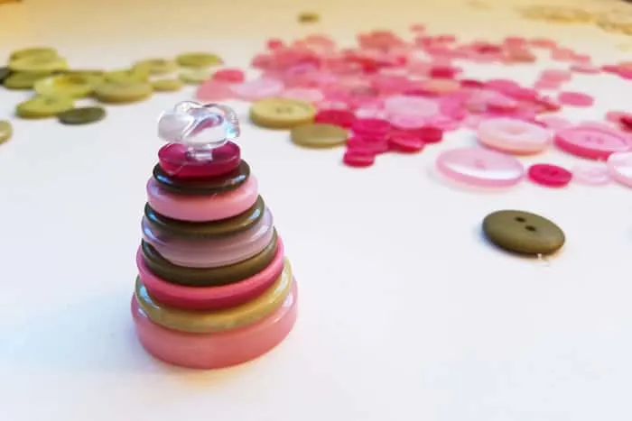 Stack of green and pink buttons with a clear topper.
