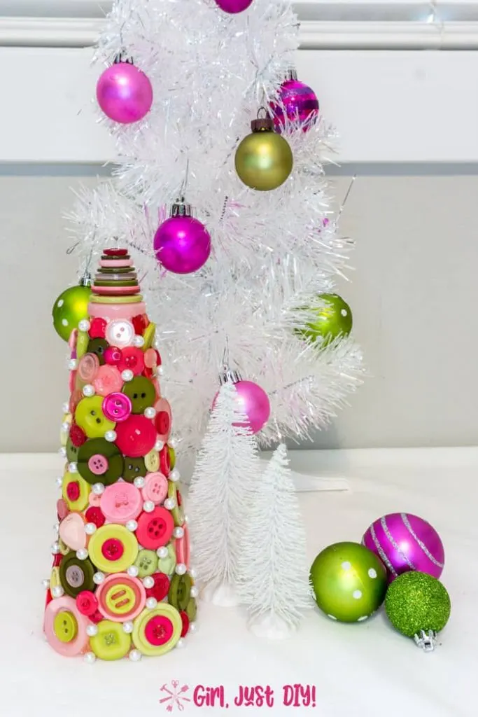 Tall picture of button Christmas tree in front of decorated table top tree.