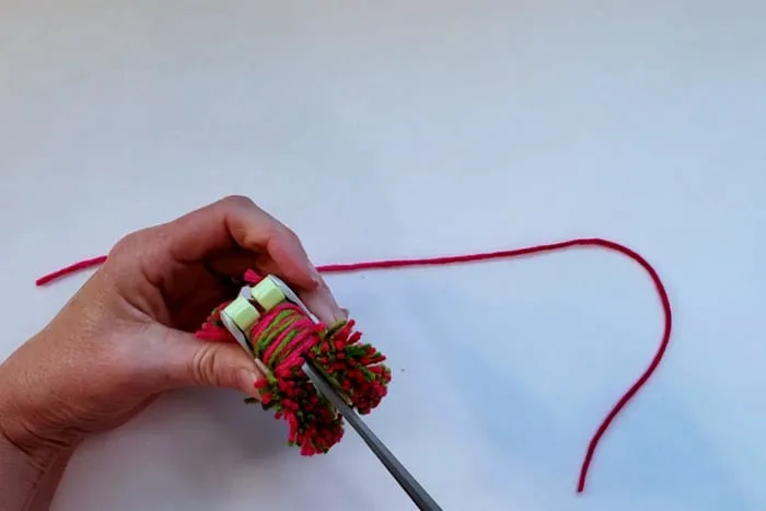 scissors cutting yarn in pompom maker