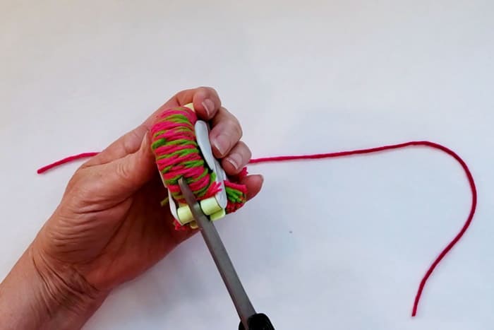 scissors cutting yarn for pompom wreath