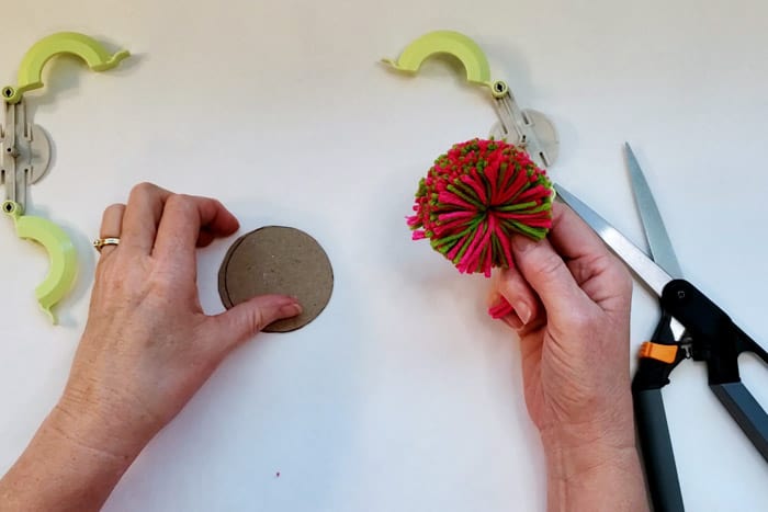 flat Pom pom held in right reach for cardboard template