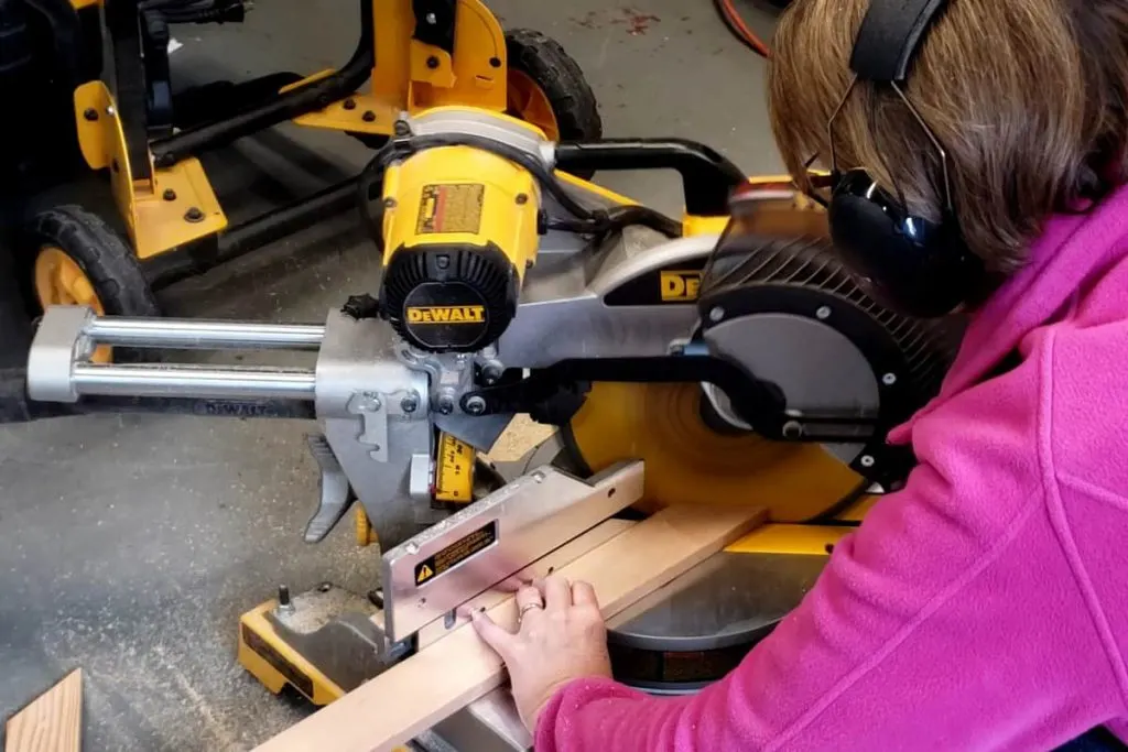 Cutting wood boards with miter saw.
