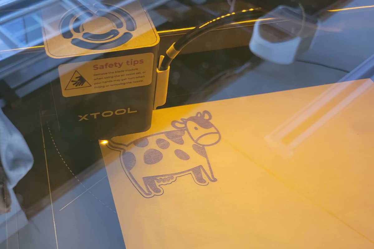 A cow illustration being laser cut after engraving