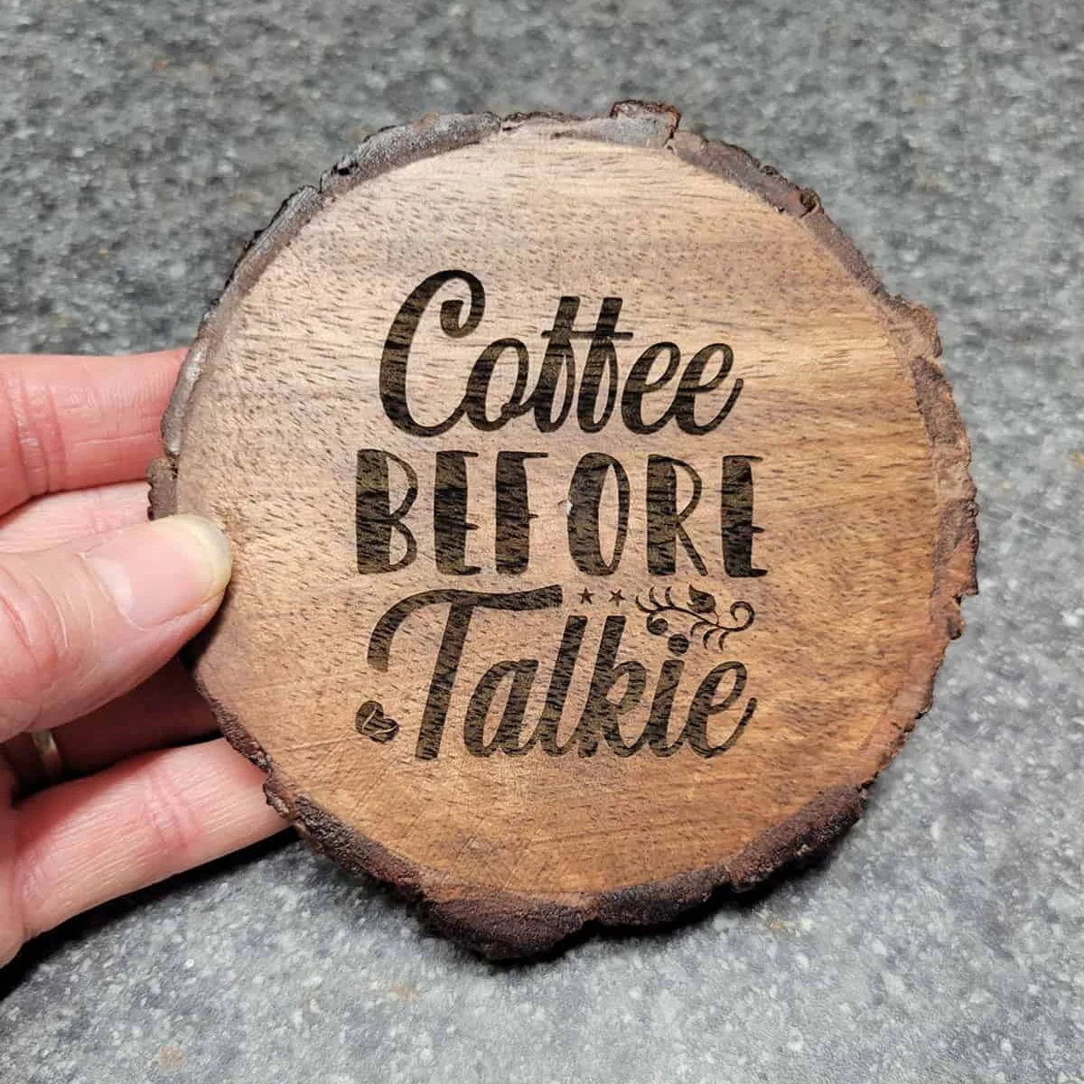 completed laser engraved wood coaster that says "coffee before talkie"