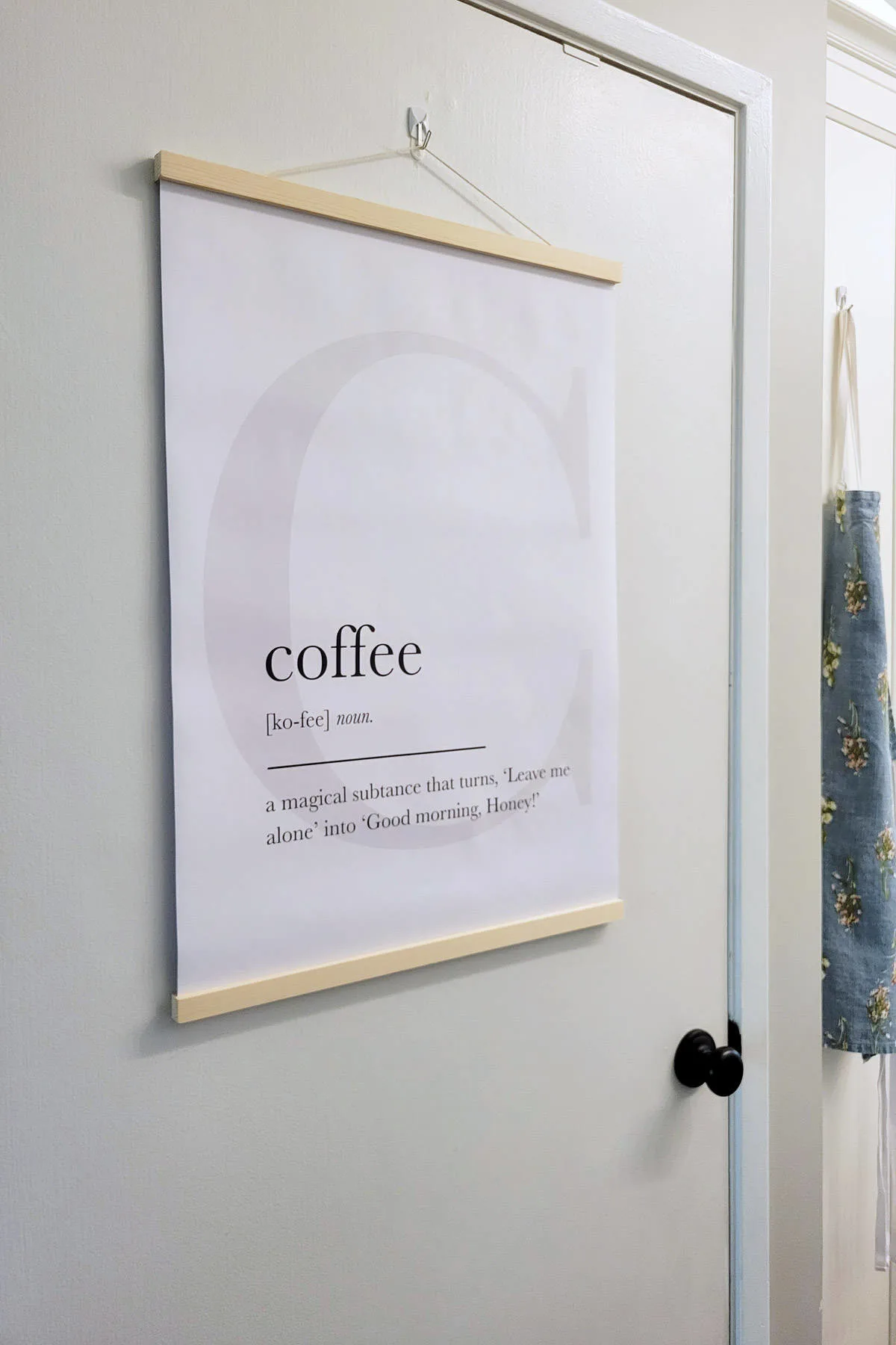 Poster with the definition of Coffee hanging on door.