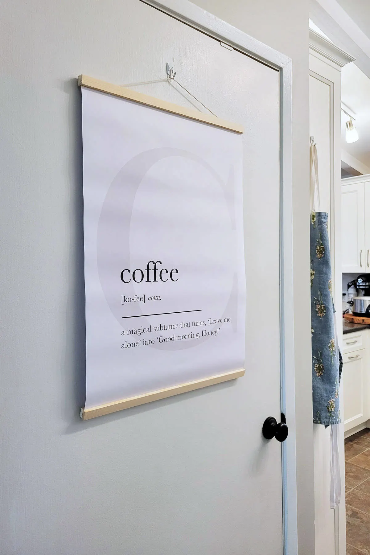 Poster with the definition of Coffee hanging on door.