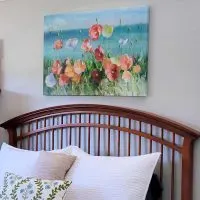 Canvas artwork of Poppies hanging on wall above bed.