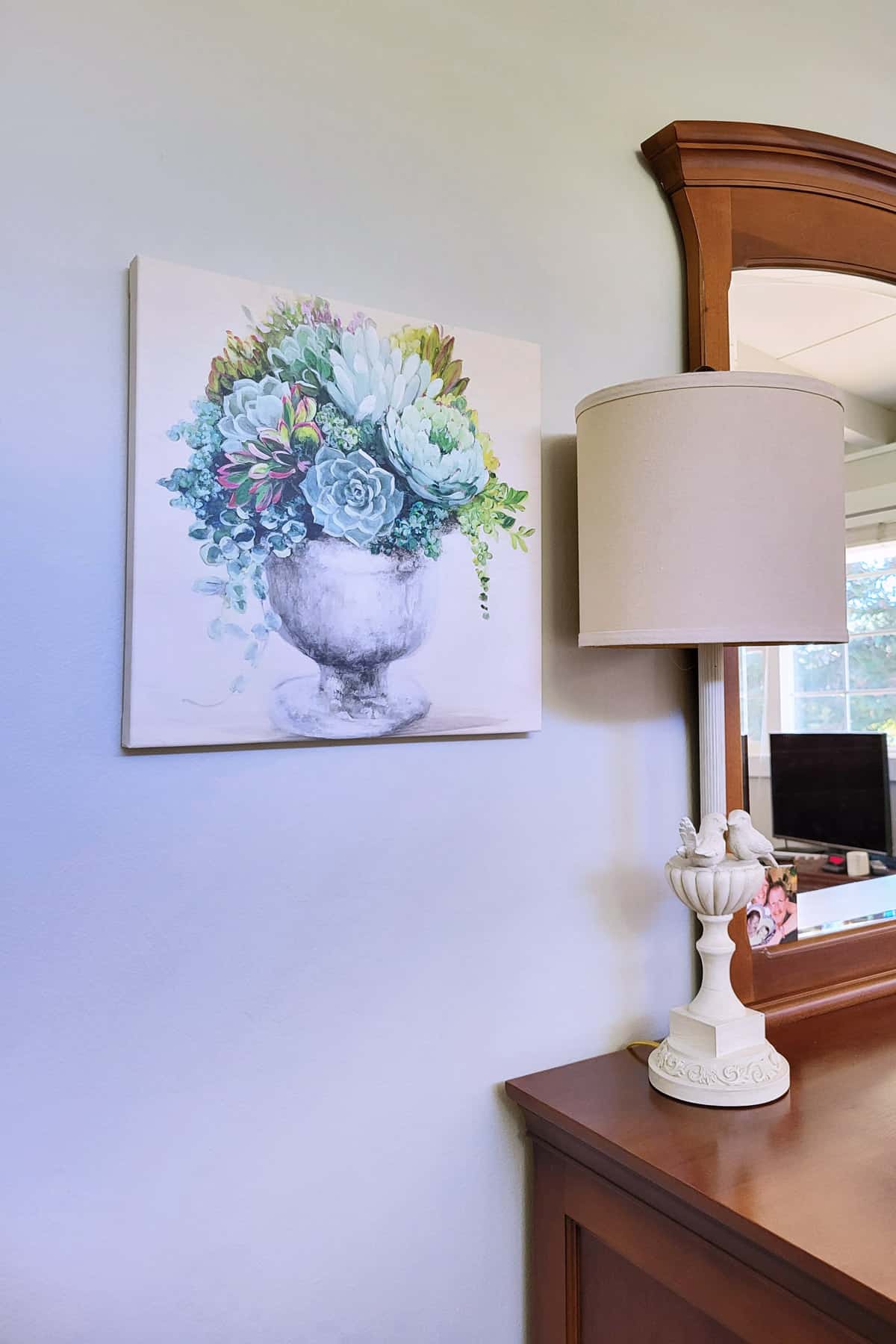 Succulent Canvas hanging on wall near lamp.