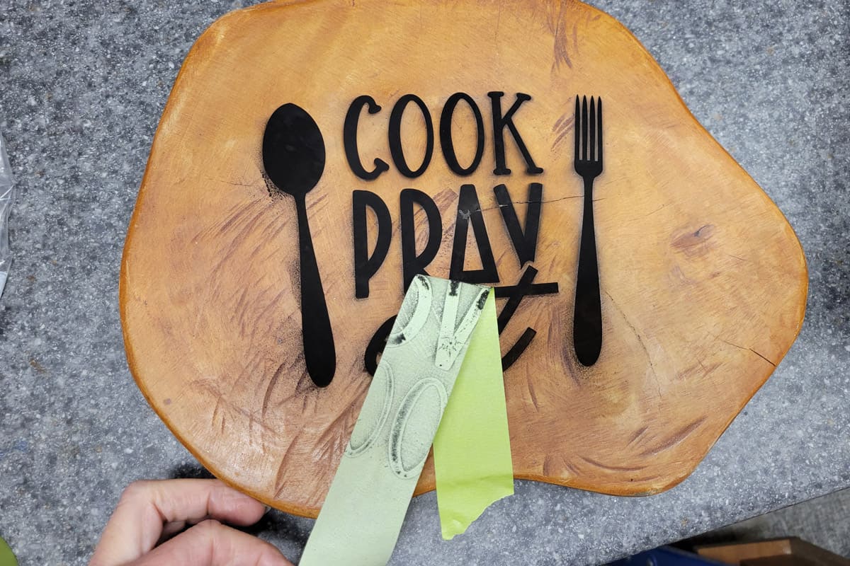 Pulling soot from laser engraved cutting board using painters tape.