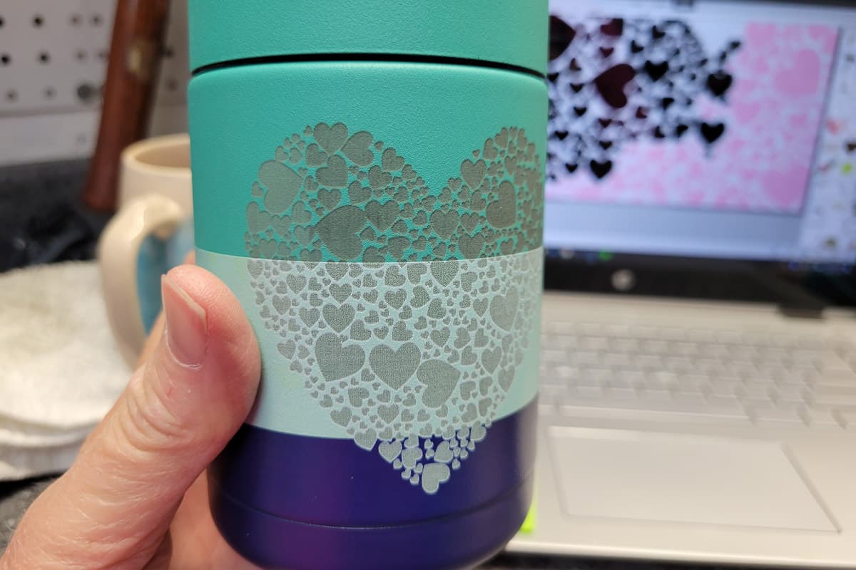Cleaned up can tumbler with hearts etched in surface.
