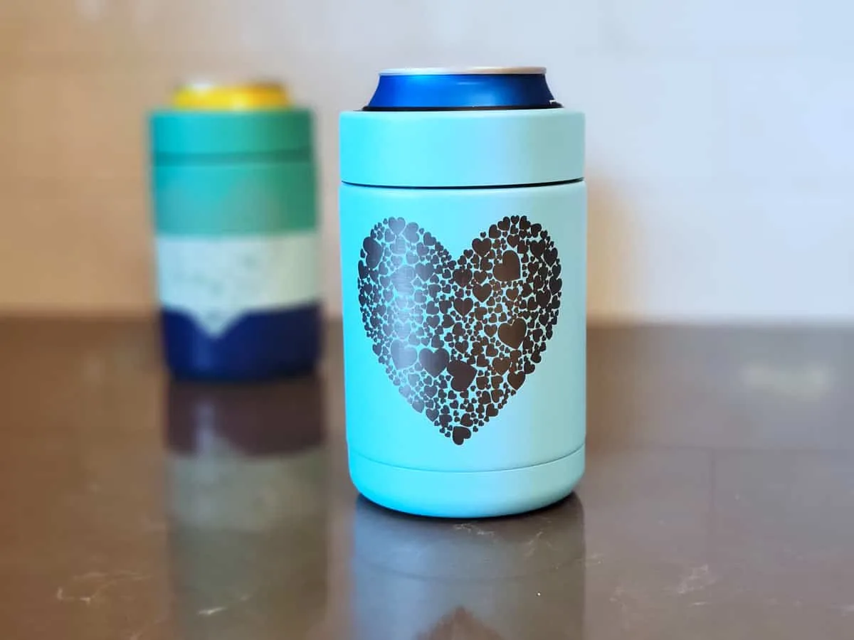 Two engraved tumblers on a counter with hearts engraved on them.